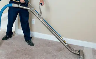 Professional operating a liquid removal machine on a carpeted floor in Albuquerque, NM